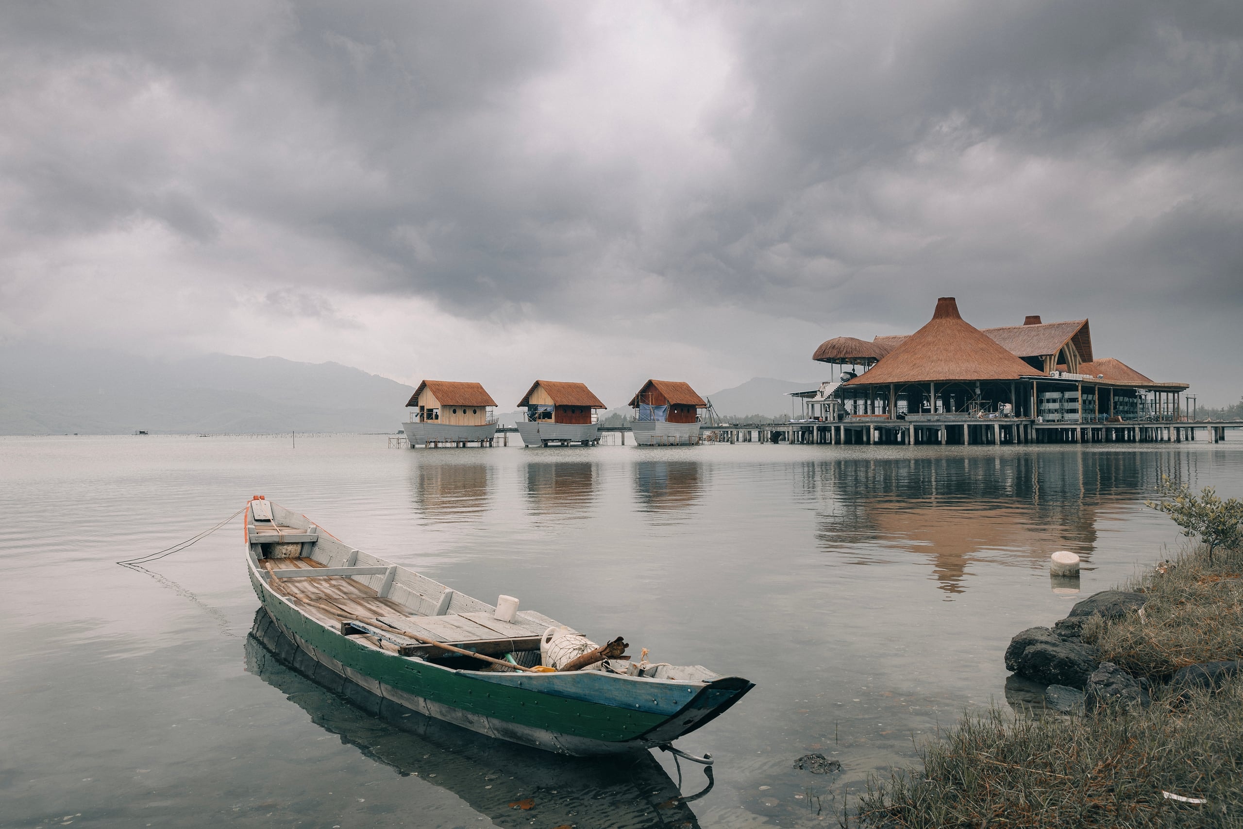 A boat at rest, the shore quiet under grey sky